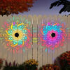 MandaGlow™ decorative solar mandala wall light projecting a colourful pattern onto an outdoor fence at night