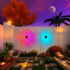MandaGlow™ decorative solar wall lights displaying colourful mandala patterns on a fence